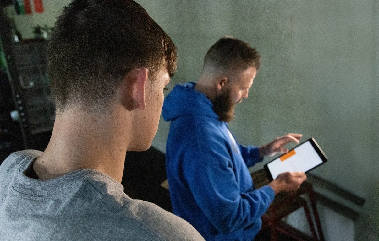 Alex Makin analyzing performance data with a collegiate athlete at AMP in a collegiate athletic training session.