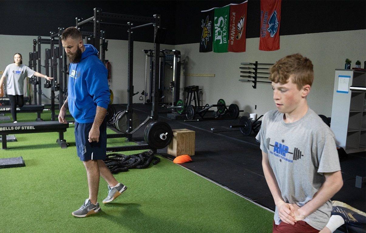 Alex Makin instructing teen athlete during warm-up at AMP's teen athletic training program.