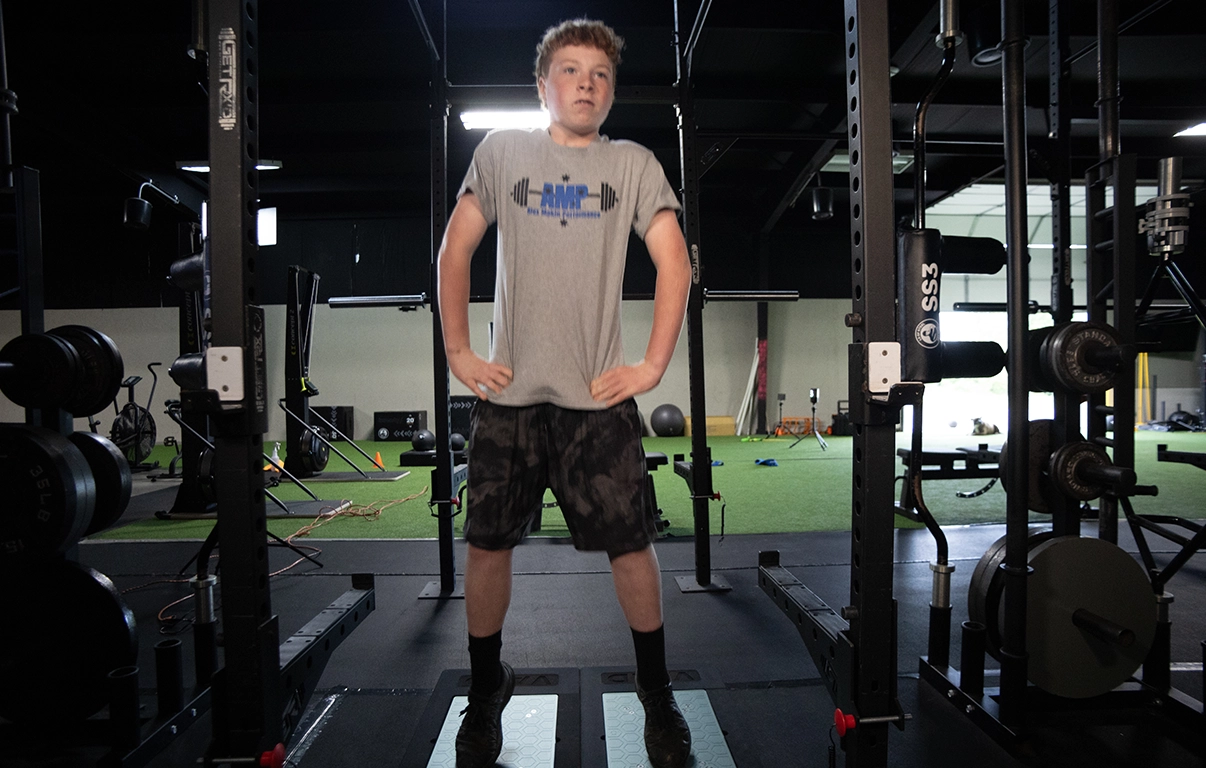 Teen athlete standing on force plates at AMP gym during a teen athletic training program.