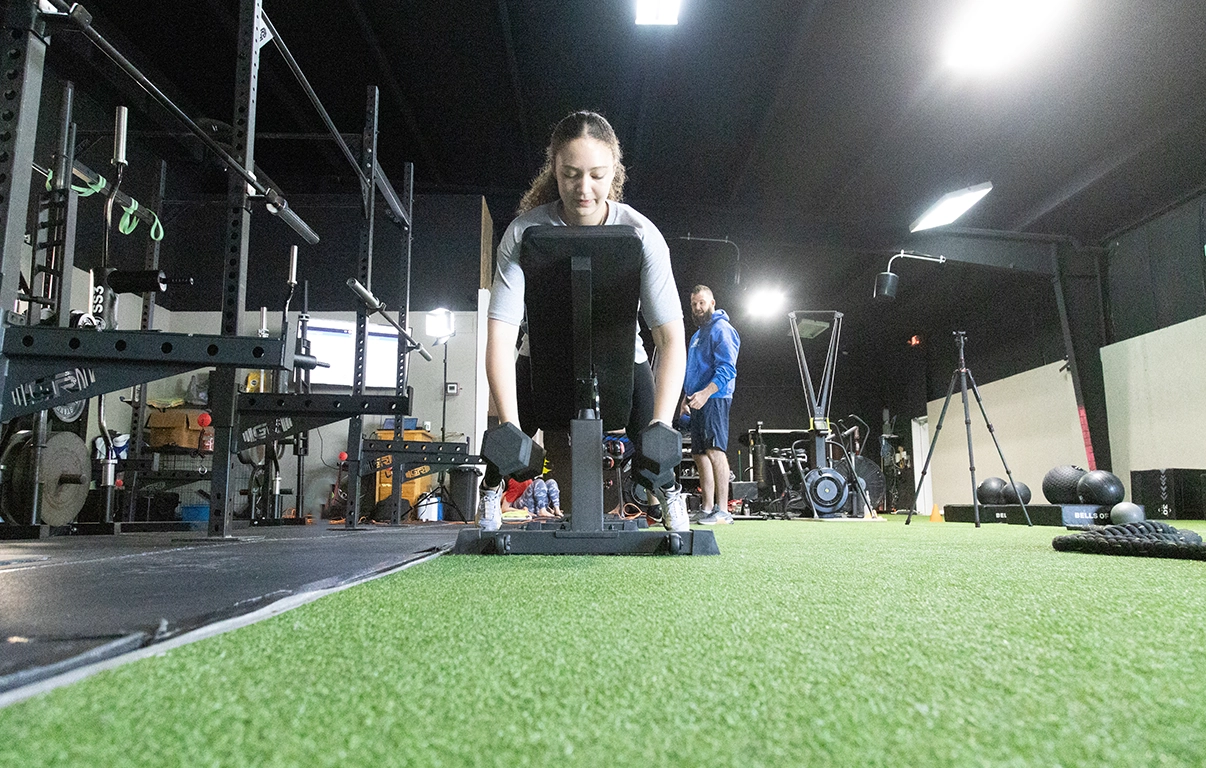 Teen athlete lifting dumbbells at AMP's teen athletic training program.