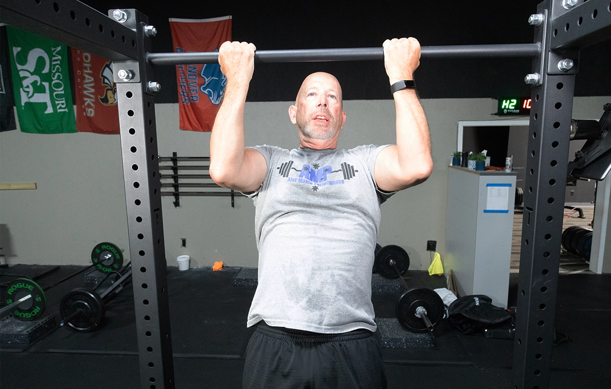 Man performing a chin-up during a strength training session at Alex Makin Performance for adult fitness training.