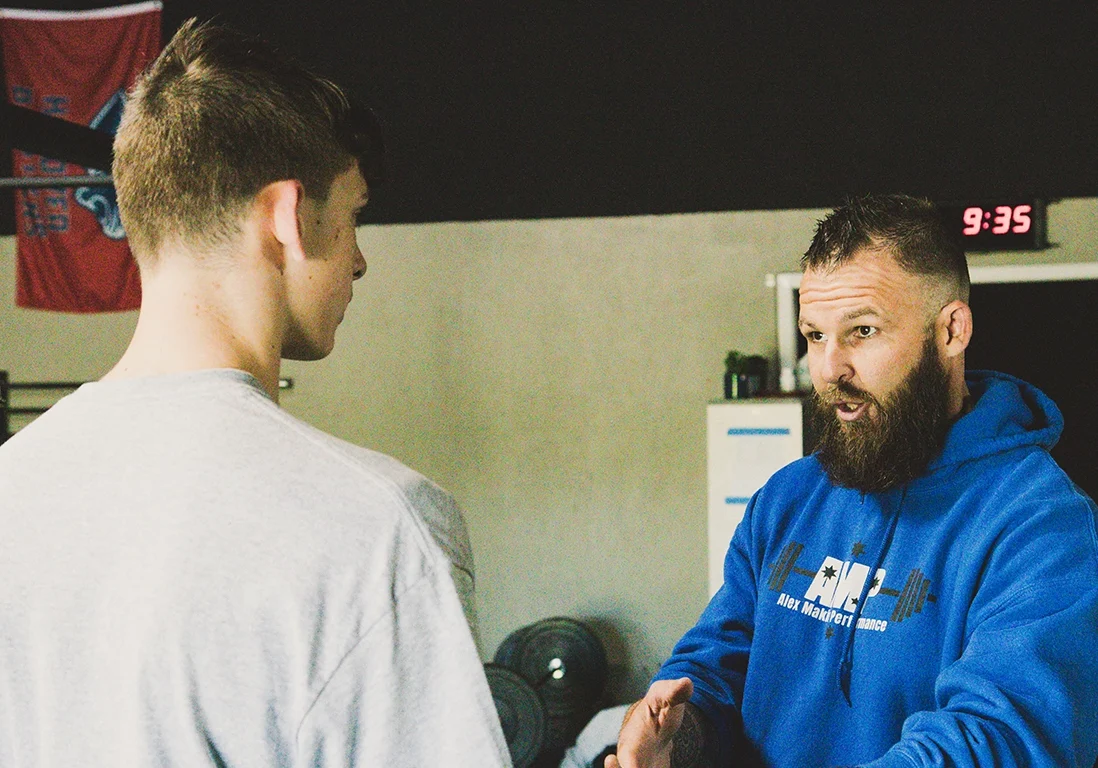 Coach Alex Makin giving one-on-one guidance to a collegiate athlete during a training session