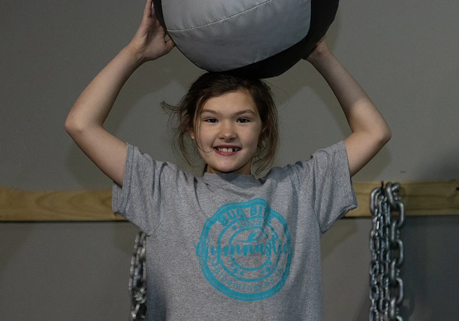 Young athlete lifting a medicine ball at Alex Makin Performance youth training.